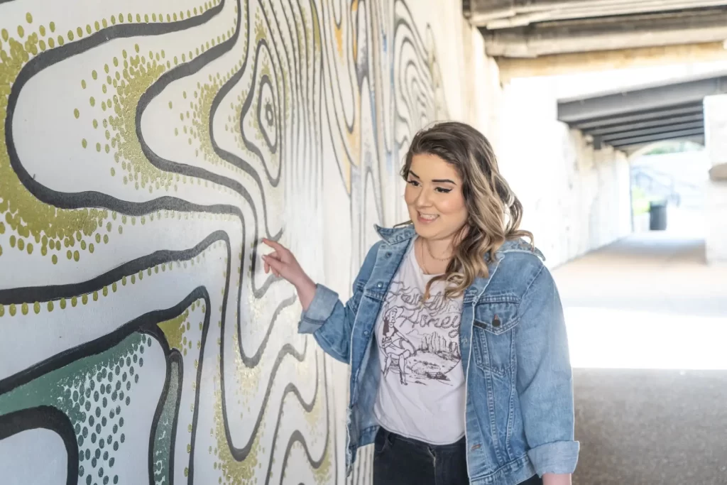 A tour guide pointing at a mural