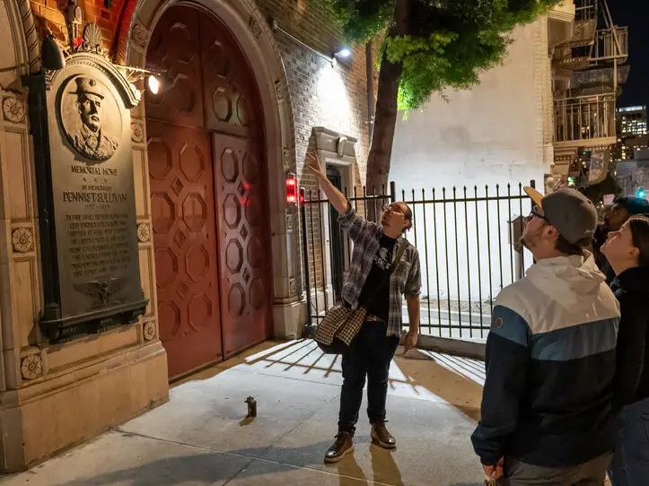 A tour guide pointing at a building