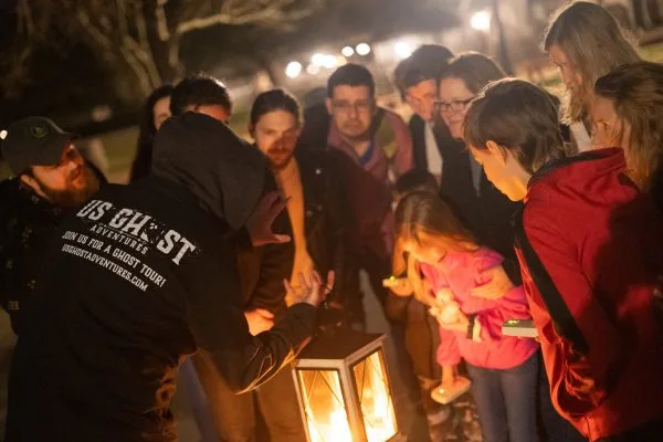 A group tour of Ghost Enthusiasts being entertained by our guide at night